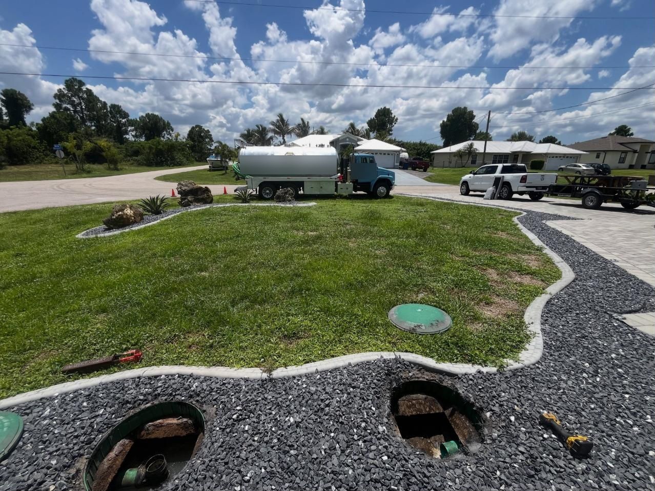 Septic tank lids opened on a Lee County property while the vacuum truck waits on the street