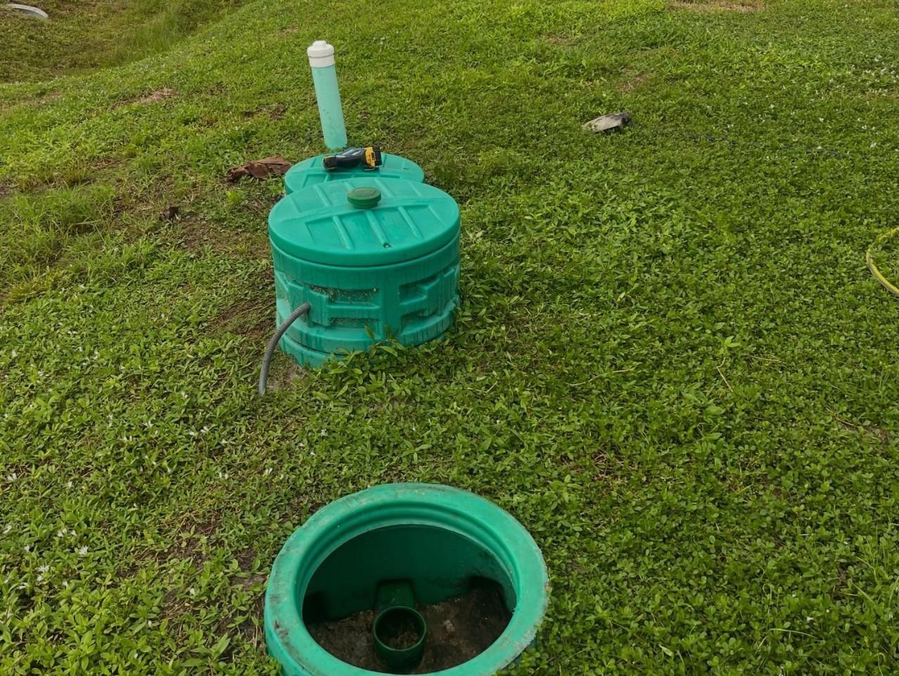 Green septic riser and lid installed at ground level on a Lee County lawn